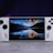 A handheld gaming console with a central screen displaying a scenic wallpaper of mountains and a lake, flanked by controller buttons and joysticks on both sides. The lighting around is dim, with purplish hues in the background, creating a modern and elegant atmosphere.